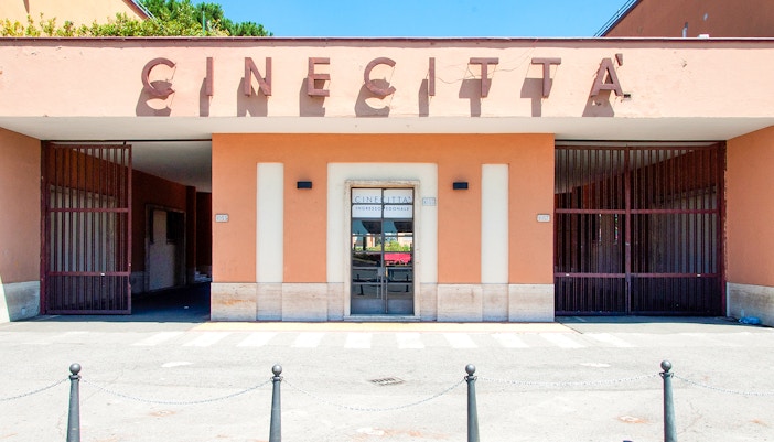 Cinecita Studios entrance with film set structures in Rome, Italy.