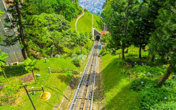 Funicular train tracks on Penang Hill surrounded by lush greenery, Penang, Malaysia.