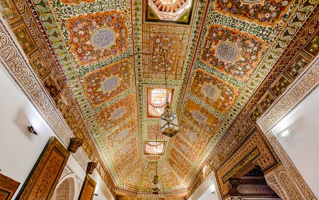 Ornate ceiling with intricate floral patterns at Bahia Palace, Marrakech, Morocco.