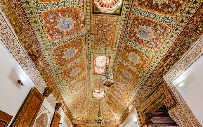 Ornate ceiling with intricate floral patterns at Bahia Palace, Marrakech, Morocco.