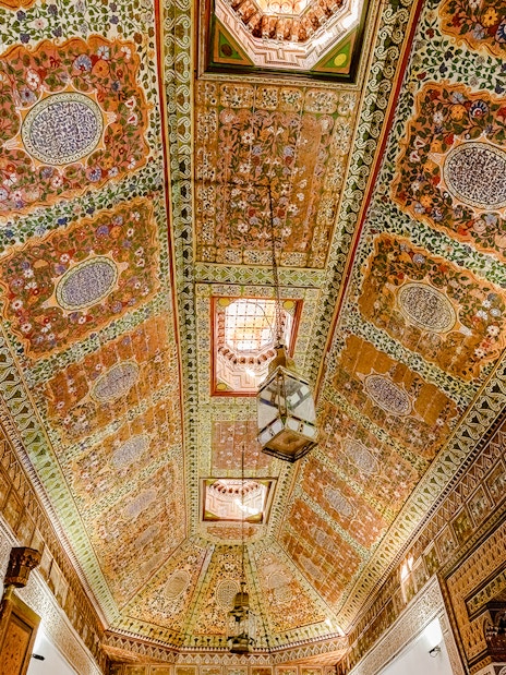 Ornate ceiling with intricate floral patterns at Bahia Palace, Marrakech, Morocco.