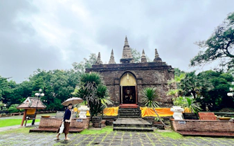 Ancient temple with spires in Chiang Mai surrounded by greenery, part of the Hidden Gems tour.
