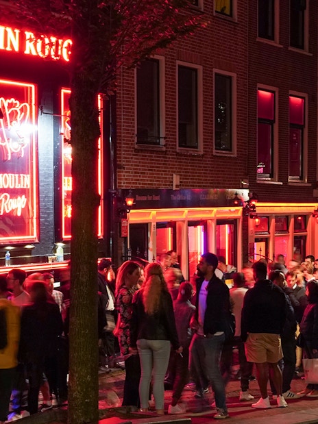 Crowd outside Moulin Rouge in Amsterdam's Red Light District at night.