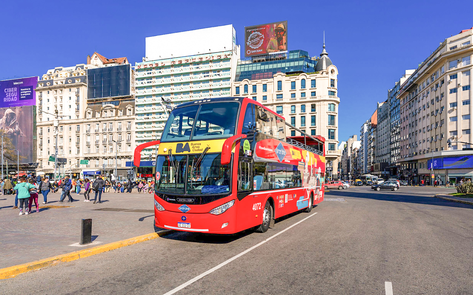 Buenos Aires hop-on hop-off tour bus in city center with historic buildings.