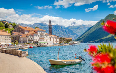 Perast old town waterfront with boats and mountains in Montenegro.