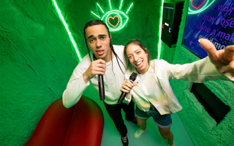People singing karaoke at The Upside Down Berlin with neon lights.