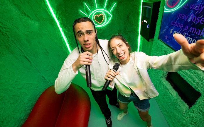 People singing karaoke at The Upside Down Berlin with neon lights.