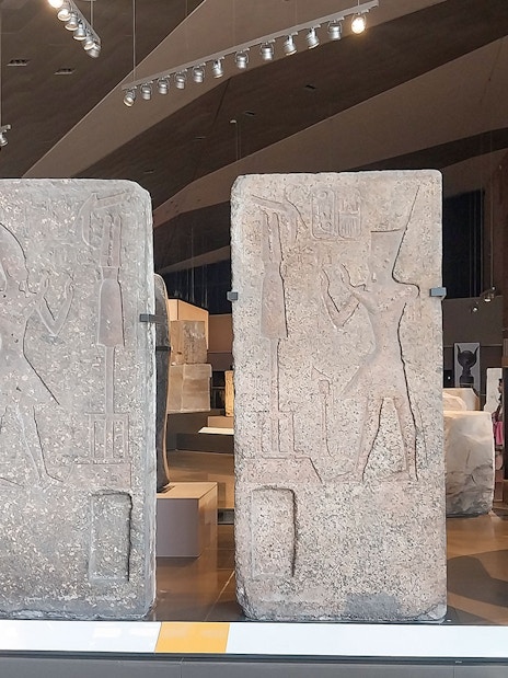 Ancient Egyptian statues and carvings inside the Grand Egyptian Museum.