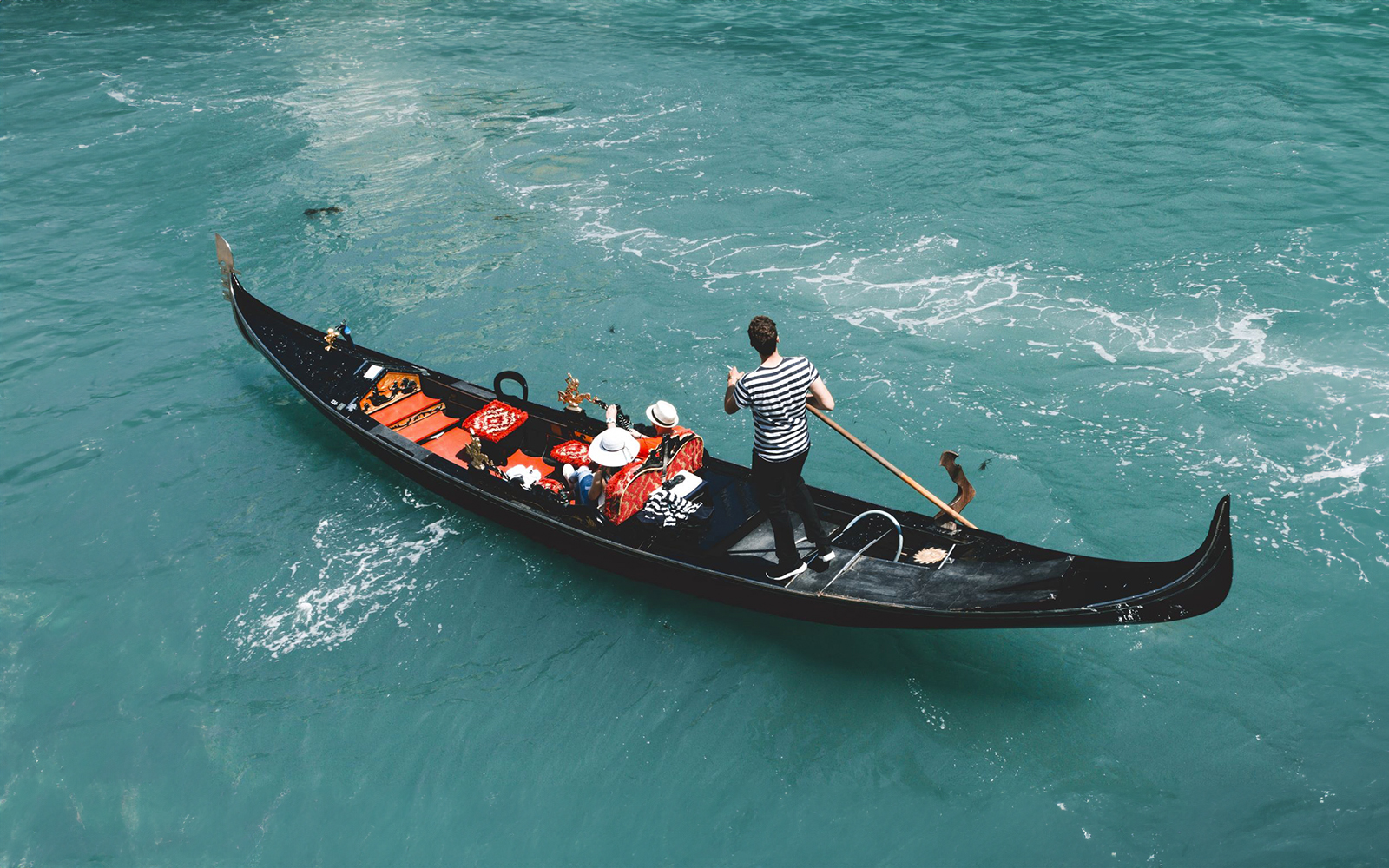 Gondola on Venice canal with passengers, part of Venice Turbopass experience.