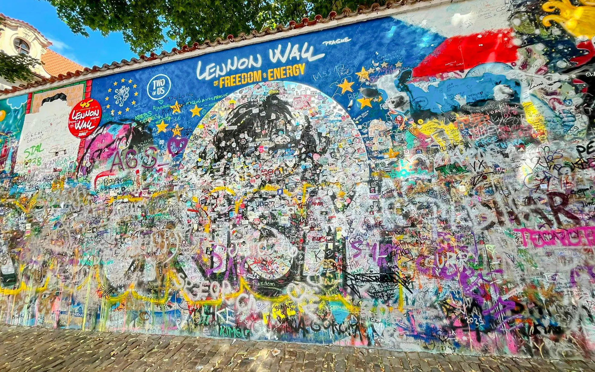 Lennon Wall in Prague covered with colorful graffiti and messages of peace.