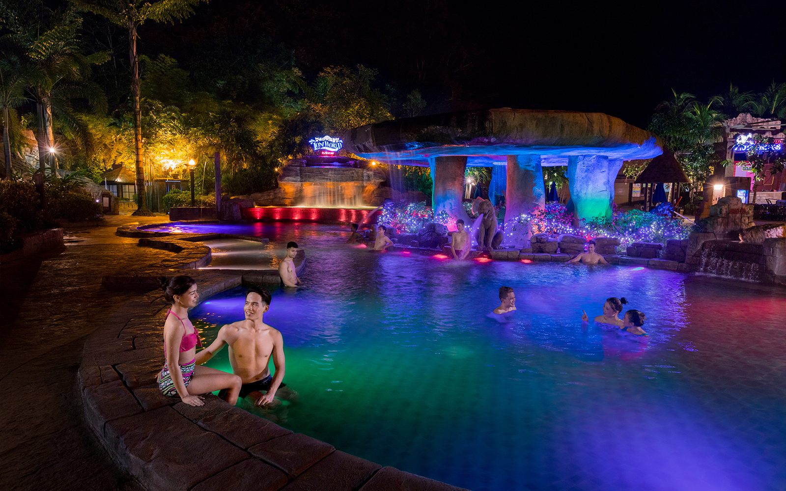 Visitors enjoying the illuminated hot springs at Sunway Lost World of Tambun at night.