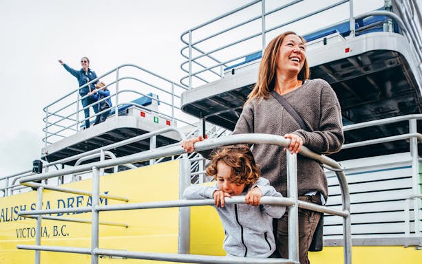 Family on boat deck during Victoria sunset whale watching tour.