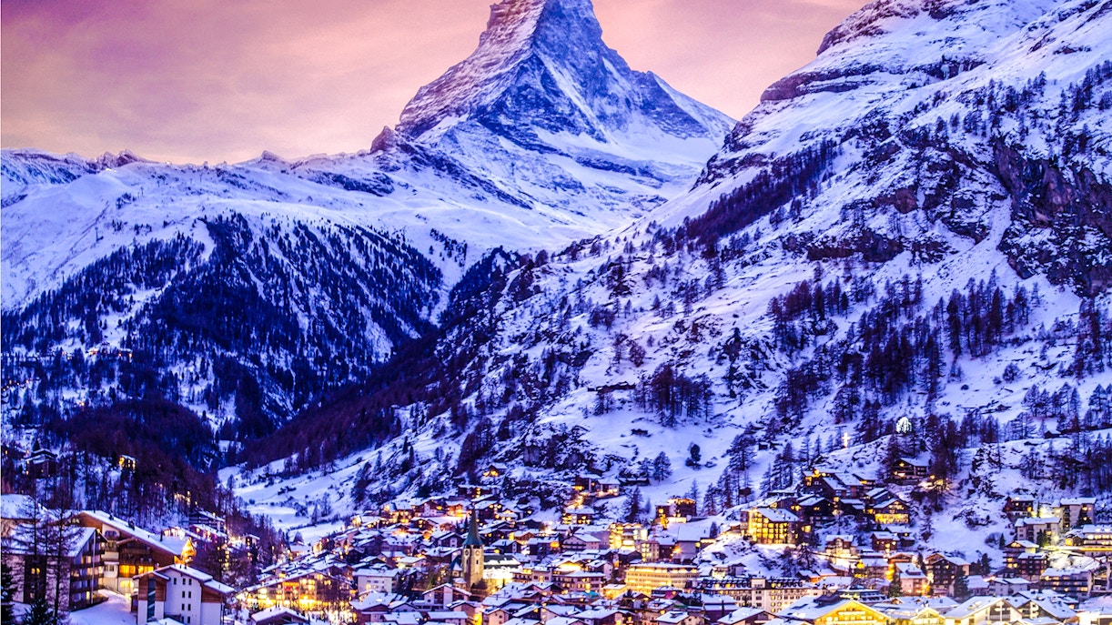 Zermatt town illuminated at twilight with the Matterhorn in the background.