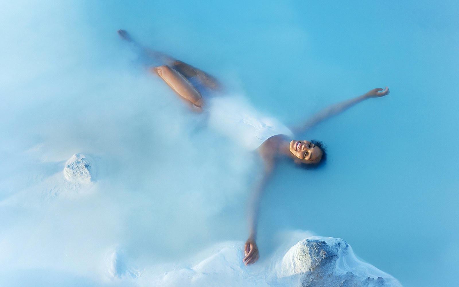 Tourist enjoying a bath in Blue Lagoon Geothermal Pool, Iceland.