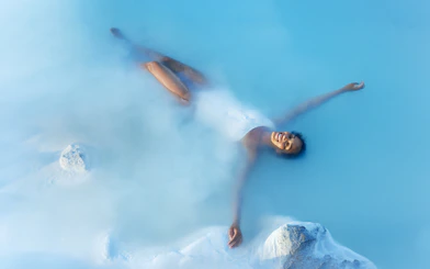 Tourist enjoying a bath in Blue Lagoon Geothermal Pool, Iceland.