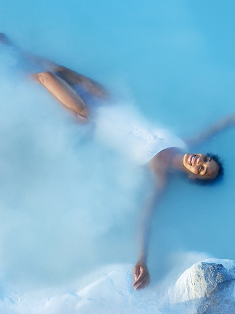 Tourist enjoying a bath in Blue Lagoon Geothermal Pool, Iceland.