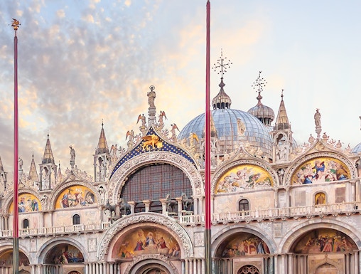 St. Mark's Basilica facade in Venice with ornate architecture and detailed mosaics.
