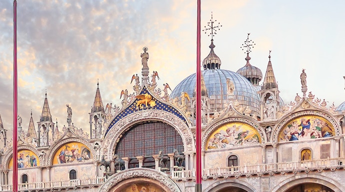 St. Mark's Basilica facade in Venice with ornate architecture and detailed mosaics.