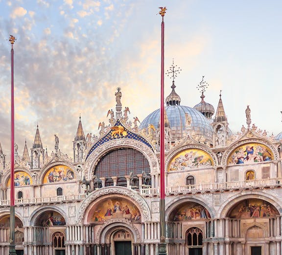 St. Mark's Basilica facade in Venice with ornate architecture and detailed mosaics.