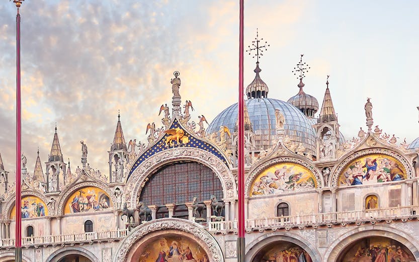 St. Mark's Basilica facade in Venice with ornate architecture and detailed mosaics.