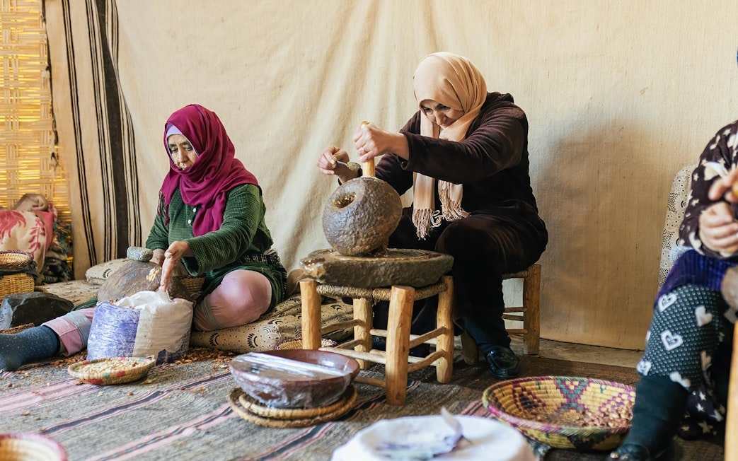 Women producing argan oil using traditional methods in Essaouira, Morocco.
