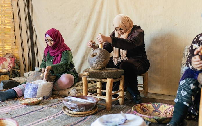 Women producing argan oil using traditional methods in Essaouira, Morocco.