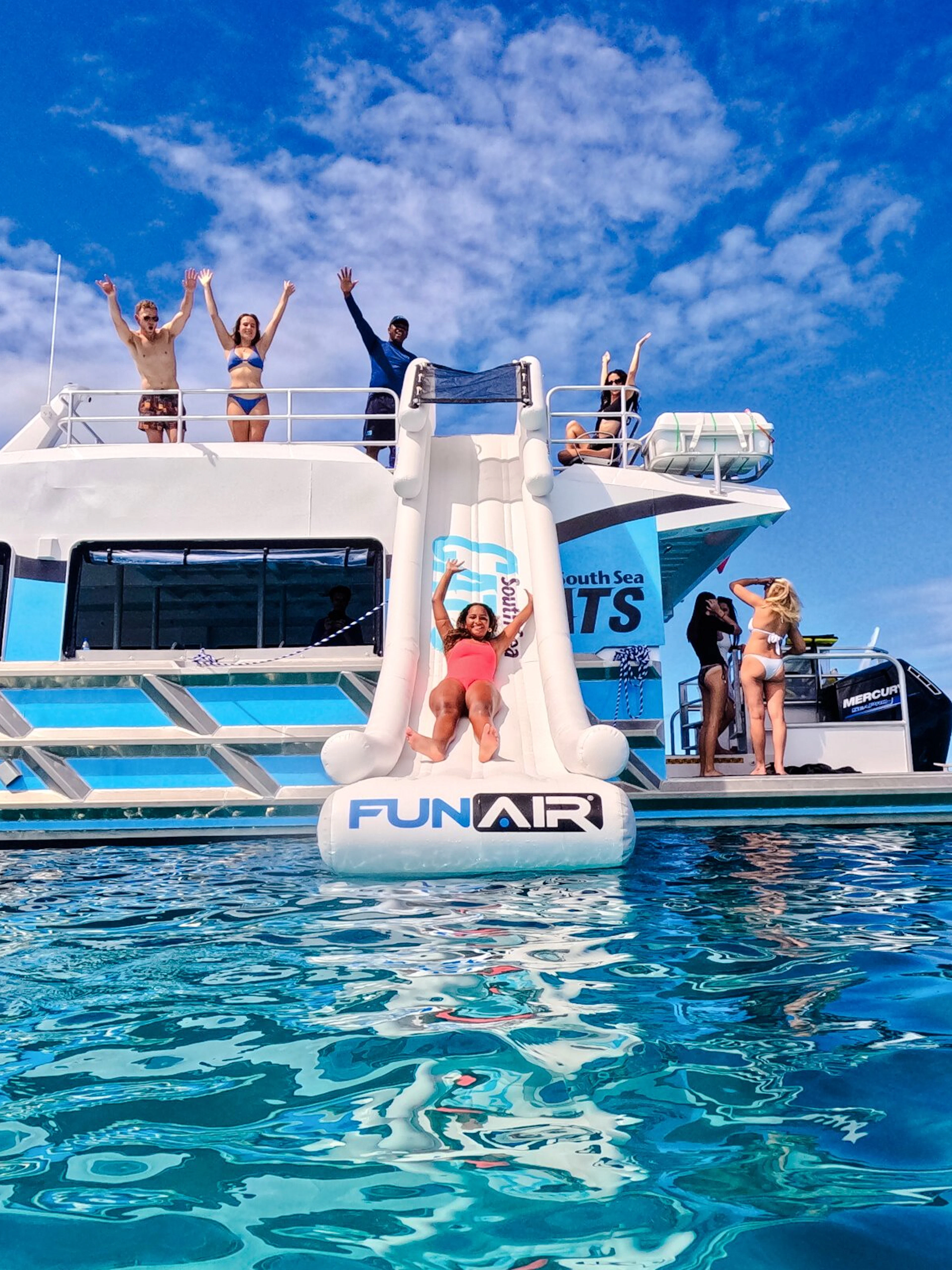 Woman sliding from Ride and Slide Catamaran in Fiji's South Sea Cats.