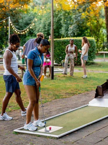 Playing mini golf at Midget Golf Rotterdam with friends in a lush garden setting.