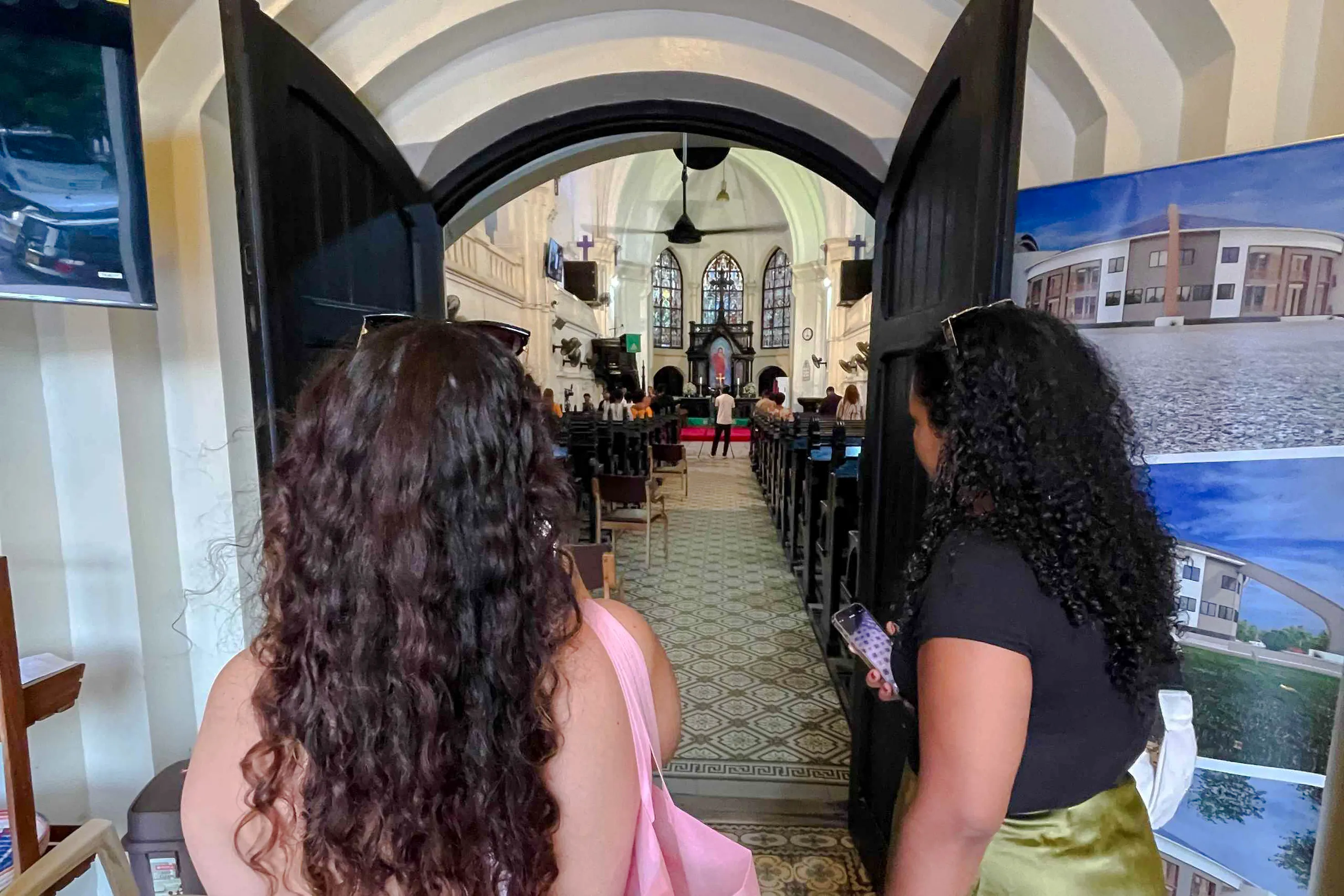 Visitors entering historic church interior, Dar es Salaam Walking Tour, Zanzibar.