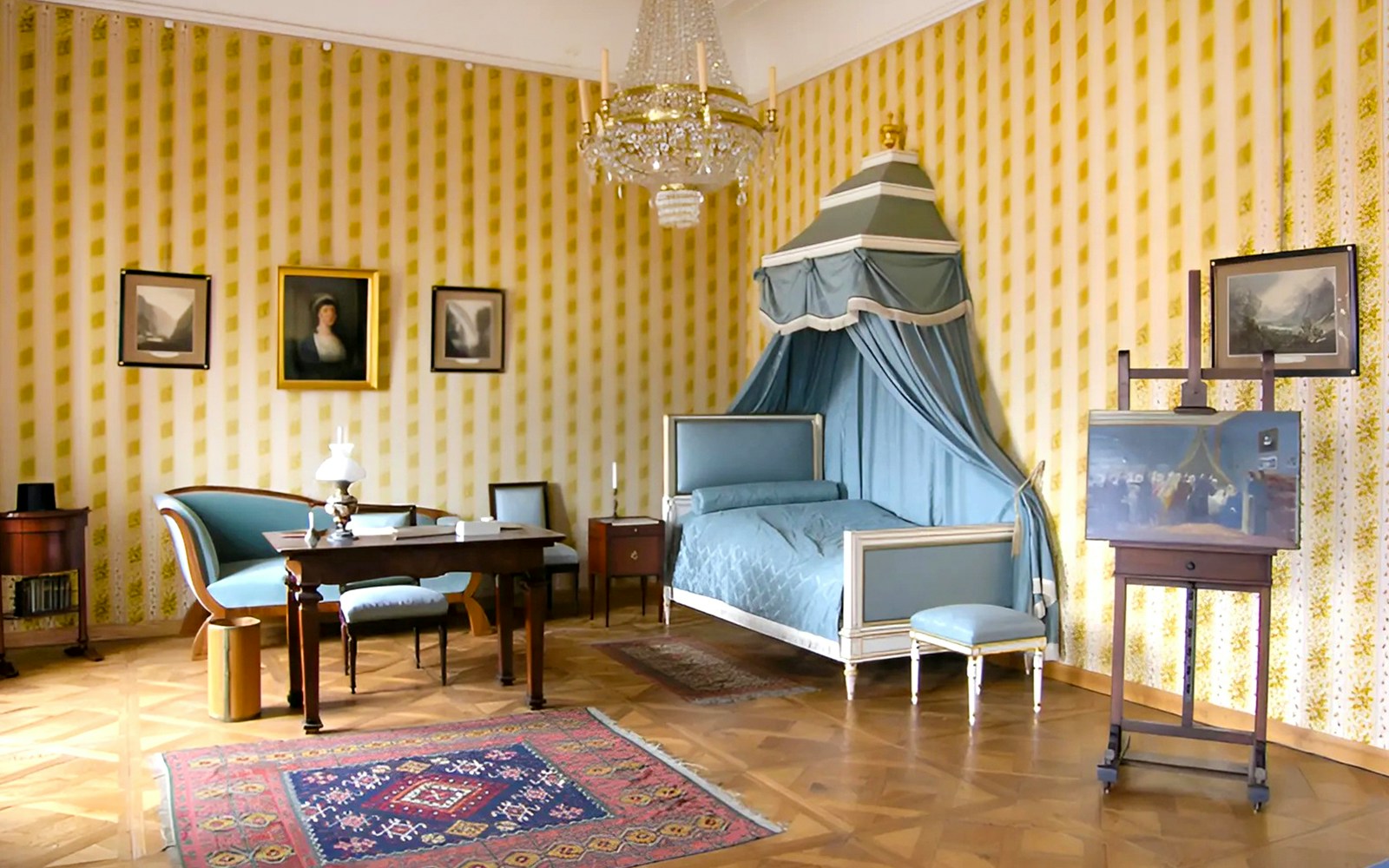 Cesky Krumlov Castle room with canopy bed, chandelier, and antique furniture.