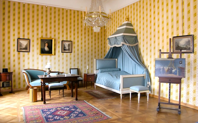 Cesky Krumlov Castle room with canopy bed, chandelier, and antique furniture.