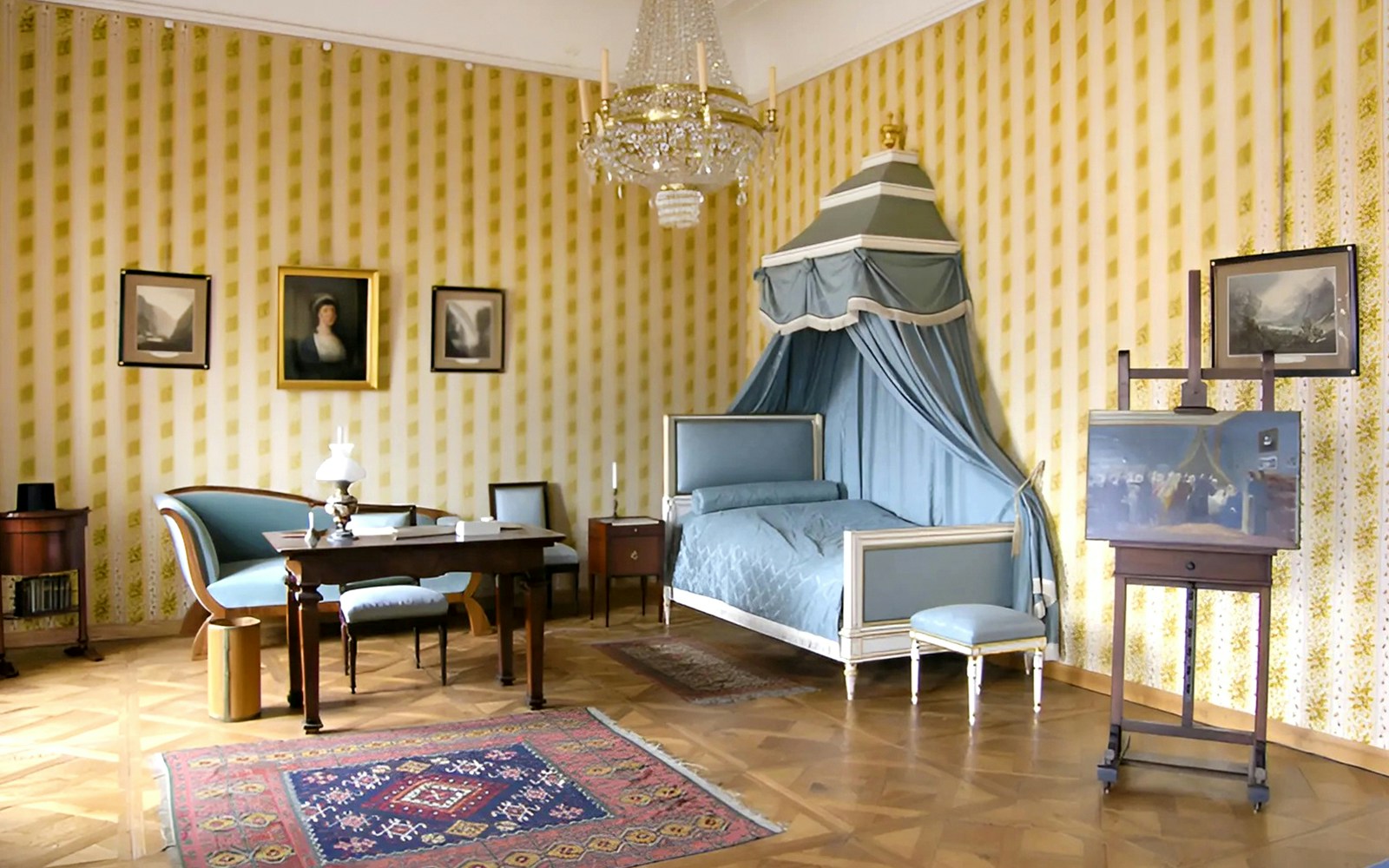 Cesky Krumlov Castle room with canopy bed, chandelier, and antique furniture.