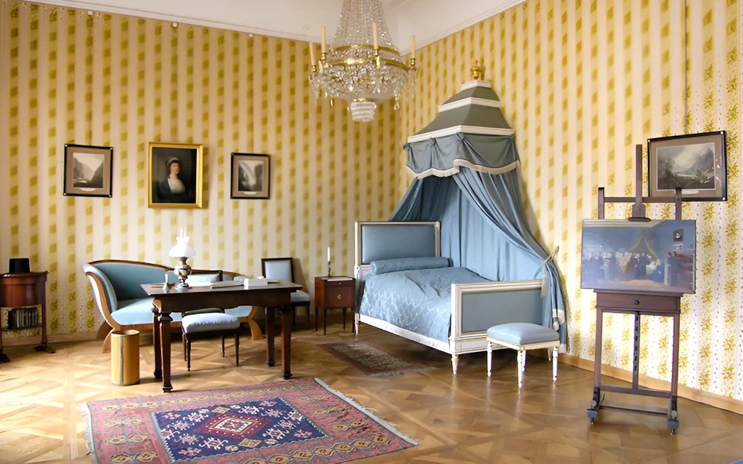 Cesky Krumlov Castle room with canopy bed, chandelier, and antique furniture.