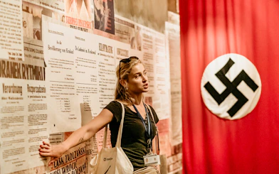 Guide explaining historical exhibits inside Oskar Schindler's Factory, Krakow, Poland.
