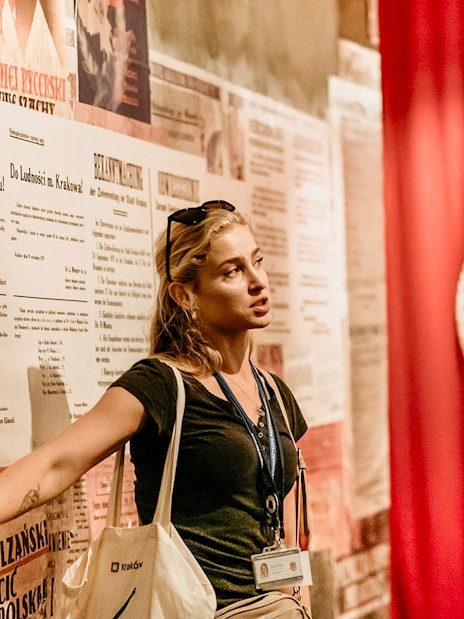 Guide explaining historical exhibits inside Oskar Schindler's Factory, Krakow, Poland.