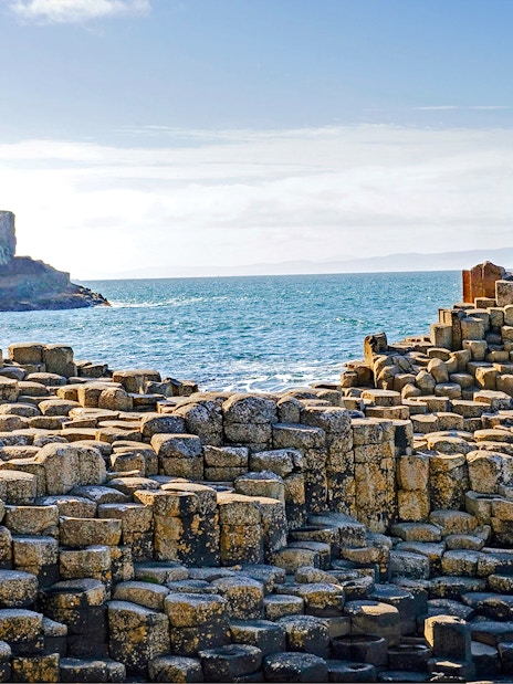 Visitors exploring the basalt columns at Giant's Causeway, Northern Ireland.