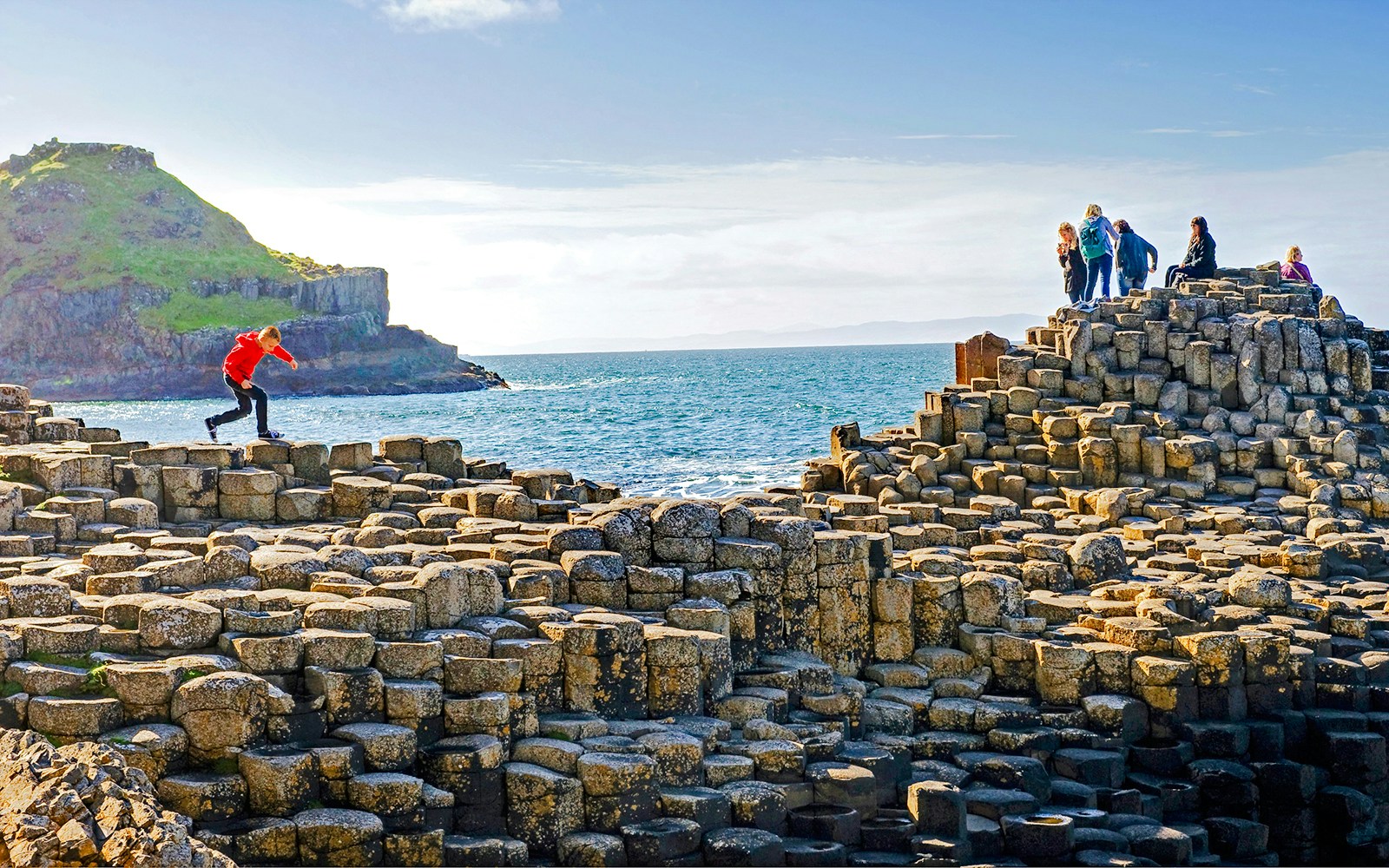 Visitors exploring the basalt columns at Giant's Causeway, Northern Ireland.