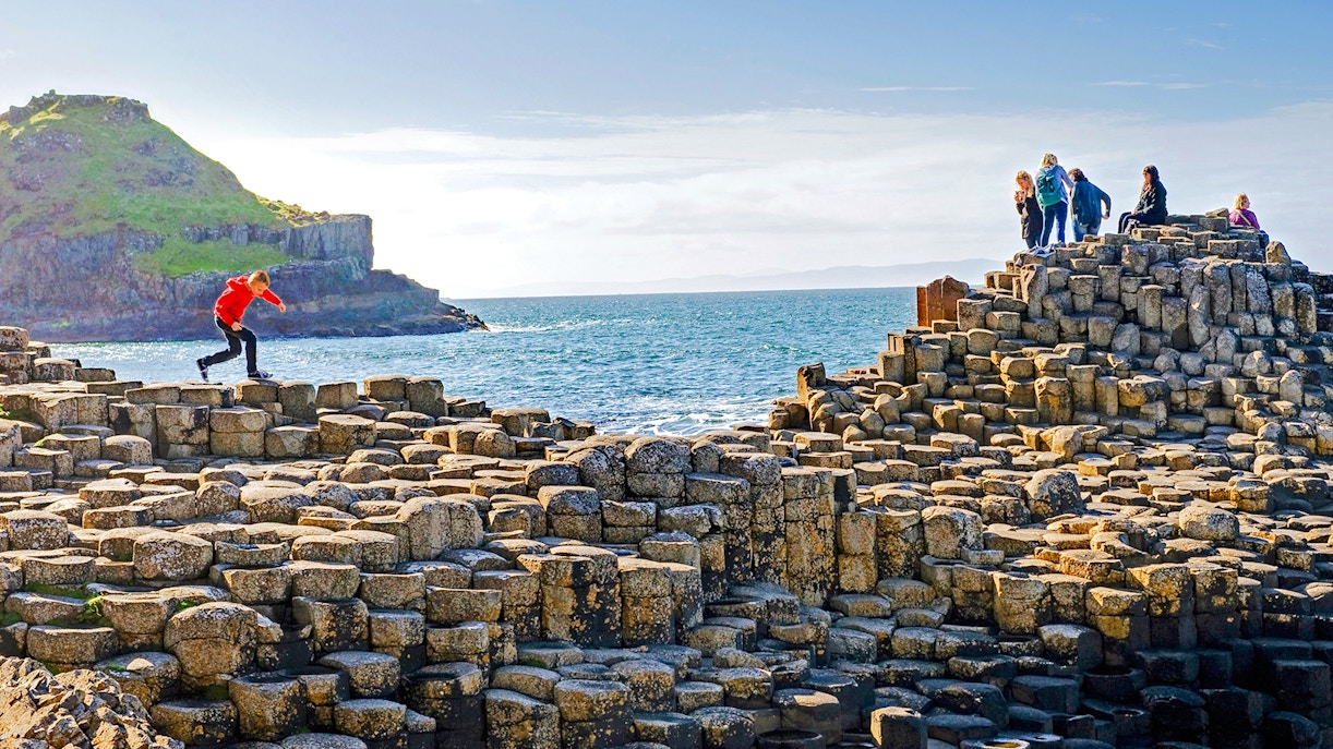 Visitors exploring the basalt columns at Giant's Causeway, Northern Ireland.