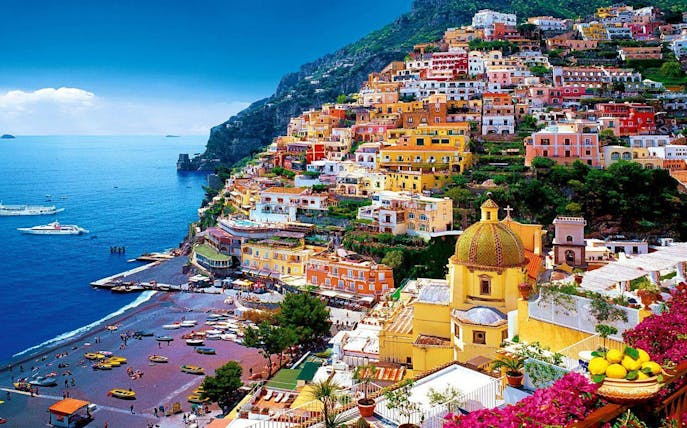 Colorful hillside buildings overlooking the sea in Positano, Italy, part of a guided tour.
