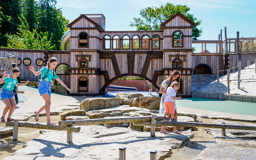 Children playing on wooden beams at the adventure play area, Blenheim Palace.