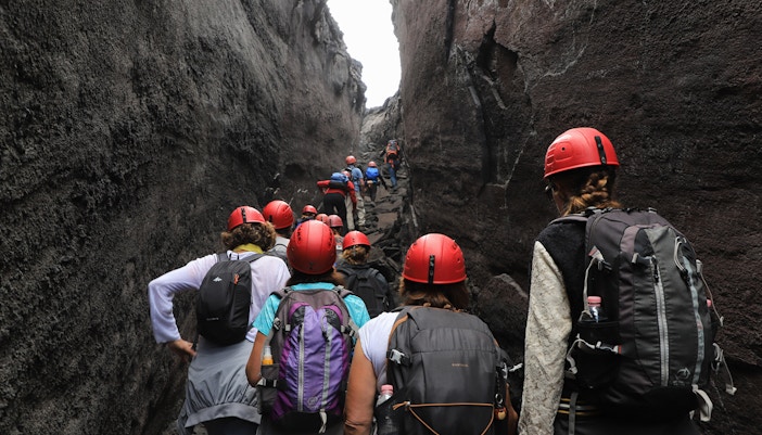 Hikers navigating narrow paths on Mount Etna during a guided tour.