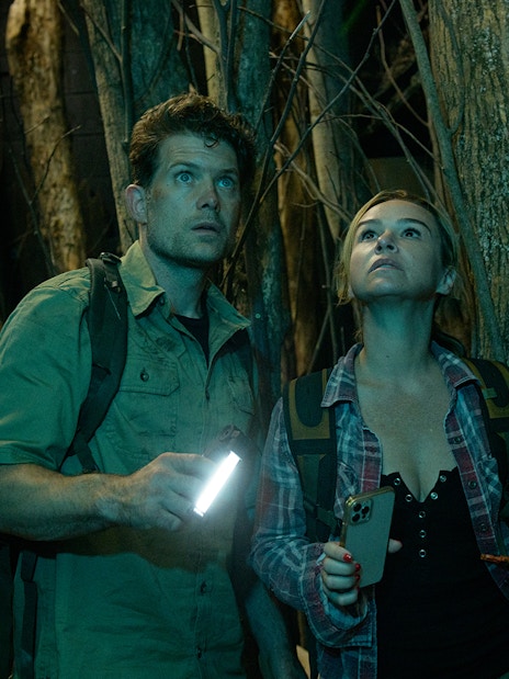 Couple exploring a dark forest with flashlights, part of Go City: Las Vegas Explorer tour.