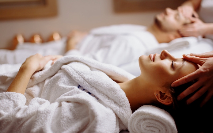 Couple receiving head massages at Spa in Therme Bucuresti.