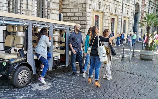 Tourists boarding a golf cart for a guided tour in Rome.