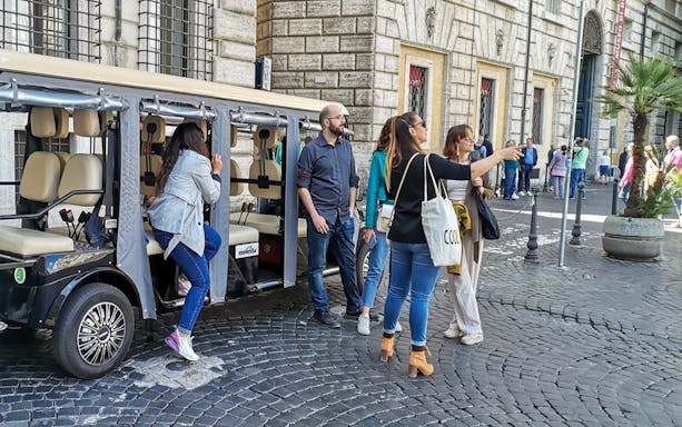 Tourists boarding a golf cart for a guided tour in Rome.