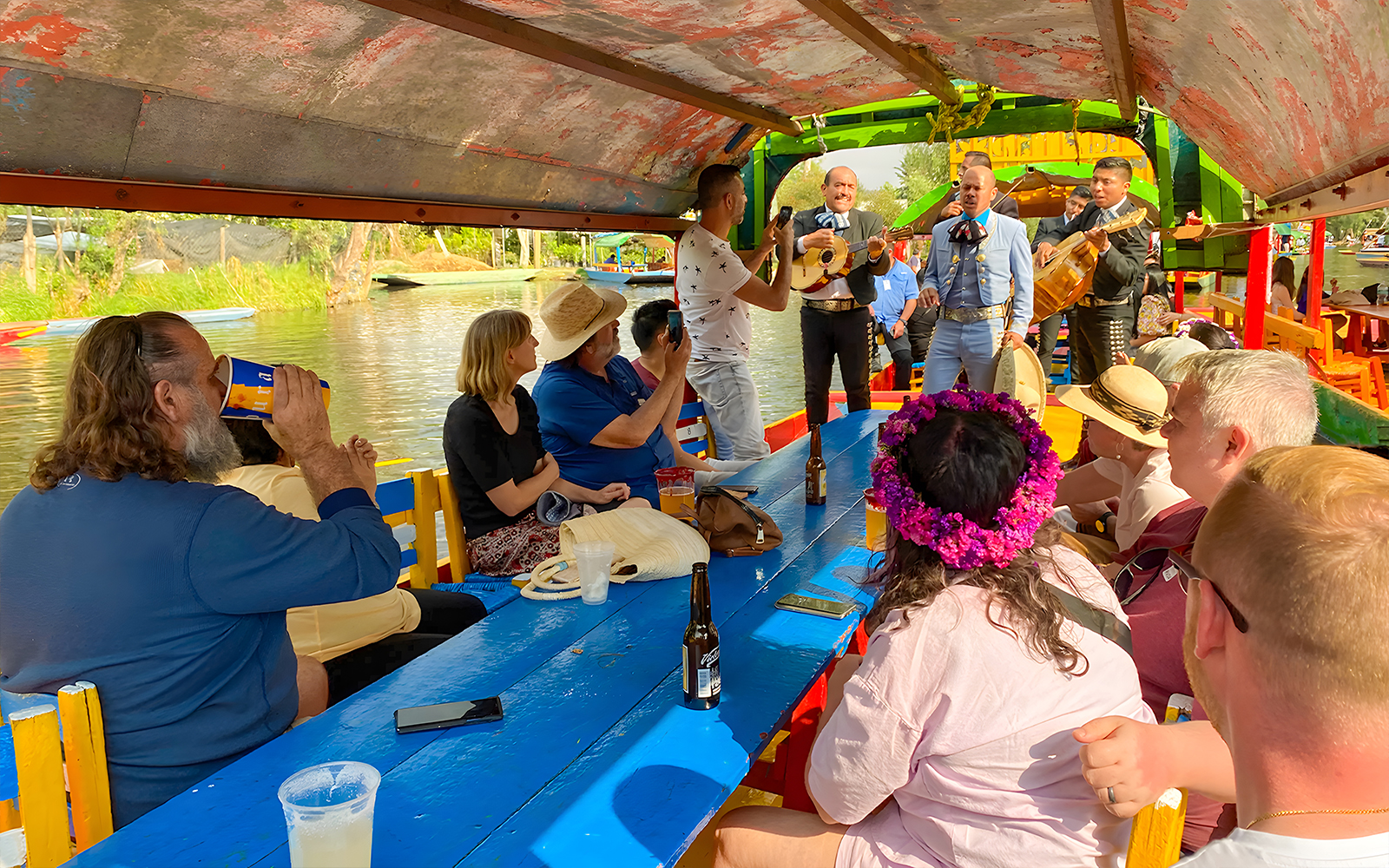 Guests enjoying live music on a Trajinera party boat in Xochimilco, Mexico.