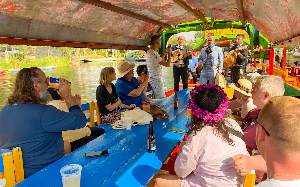 Guests enjoying live music on a Trajinera party boat in Xochimilco, Mexico.