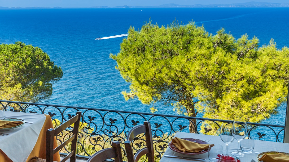 Capri waterfront dining with view of Faraglioni rock formations.