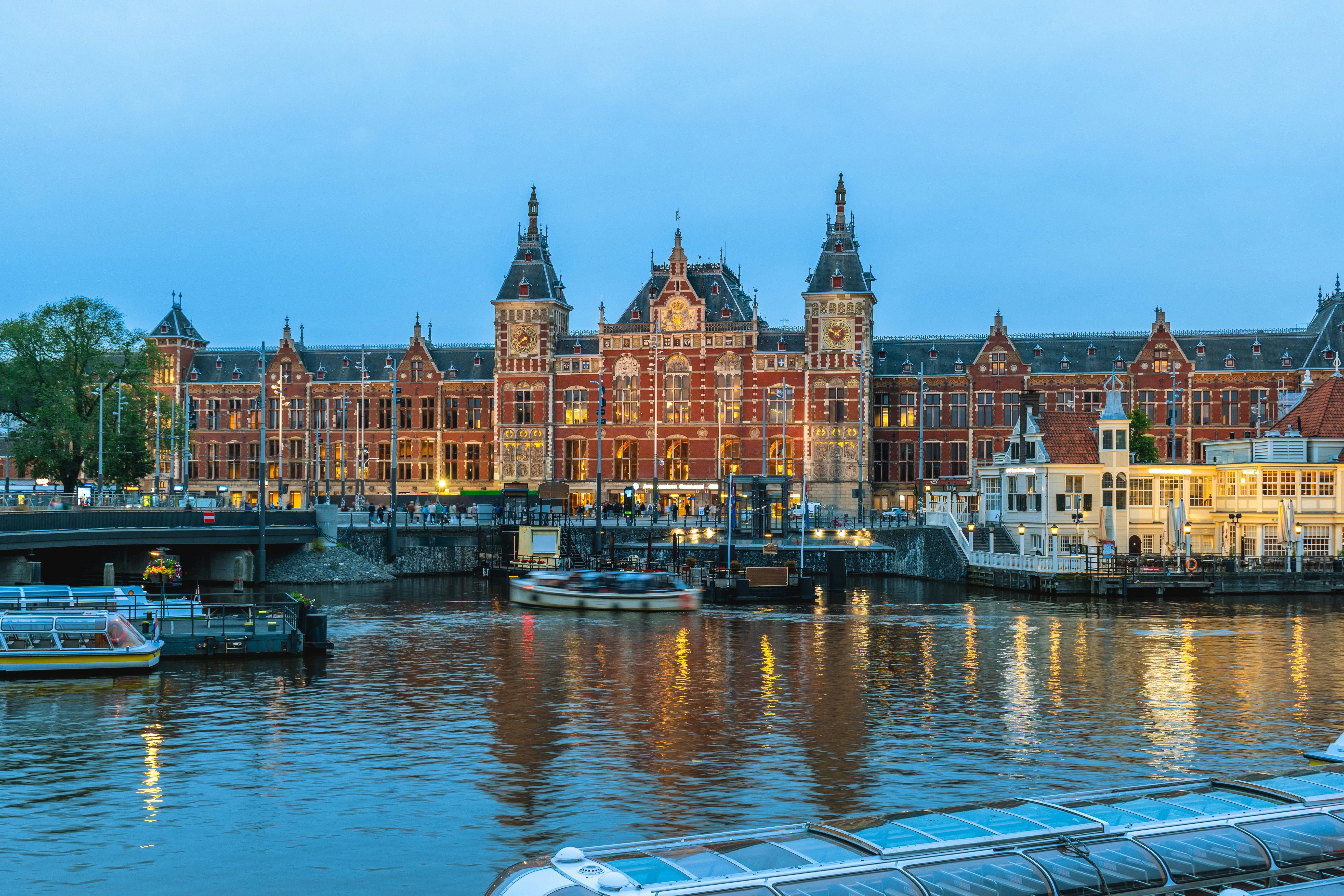 Amsterdam Centraal station with canal boats in North Holland, Netherlands.