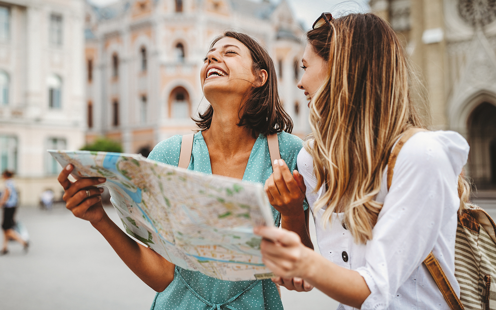 Tourists exploring a city with a map in front of historic architecture.